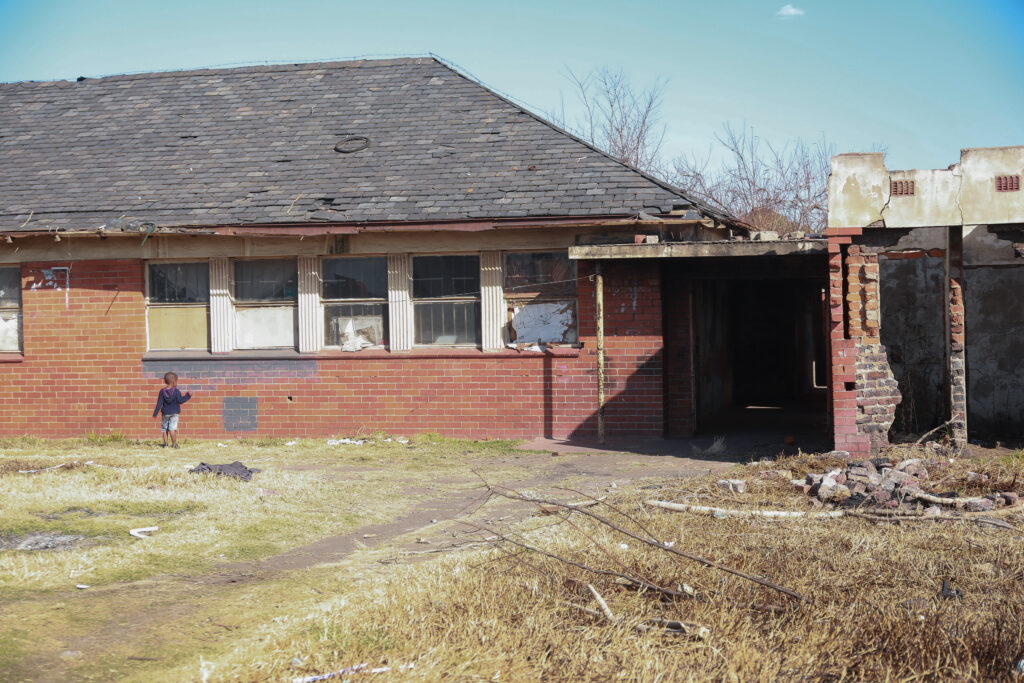 Old Vereeniging Hospital. A little boy is standing in front of the ruins.